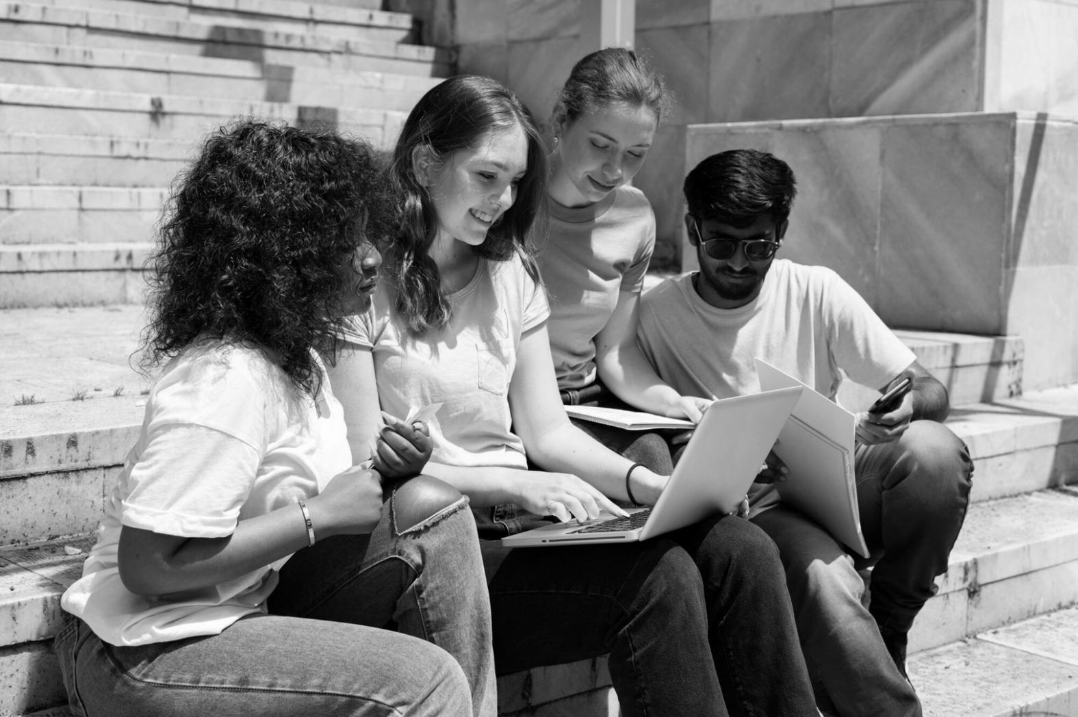 Estudiantes trabajando en análisis financiero con datos y gráficos en pantalla